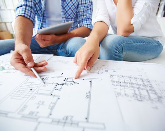 Hands of young couple during discussion of plan of flat